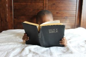 Kind studiert Bibel